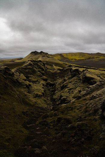 View of moss covered lava fields stretch toward the horizon under a cloudy sky showcasing rugged beauty Skaftárhreppur Iceland. View of moss covered lava fields stretch toward the horizon under a cloudy sky showcasing rugged beauty Skaftárhreppur Iceland.