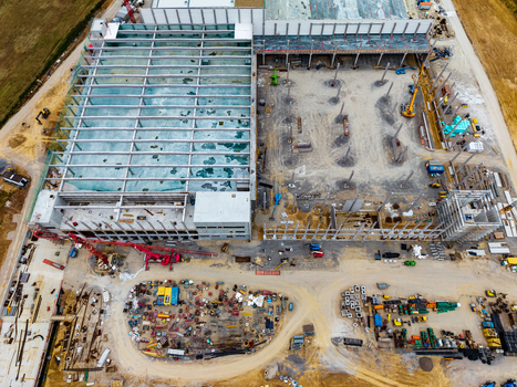 Aerial view of Neuenstein Techno Zone construction site with a large warehouse structure steel beams heavy machinery and building materials in Neuenstein Baden Wurttemberg Germany. Aerial view of Neuenstein Techno Zone construction site with a large warehouse structure steel beams heavy machinery and building materials in Neuenstein Baden Wurttemberg Germany.