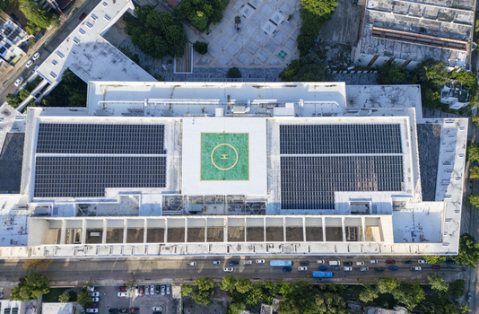 Aerial view of the Centro Internacional de Congresos de Yucatan featuring a large rooftop helipad and extensive solar panel arrays in the urban landscape of Merida Yucatan Mexico. Aerial view of the Centro Internacional de Congresos de Yucatan featuring a large rooftop helipad and extensive solar panel arrays in the urban landscape of Merida Yucatan Mexico.