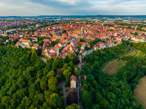 Aerial view of the historic town of Rothenburg ob der Tauber with iconic red rooftops and medieval architecture surrounded by lush forests in Rothenburg ob der Tauber Bavaria Germany. Aerial view of the historic town of Rothenburg ob der Tauber with iconic red rooftops and medieval architecture surrounded by lush forests in Rothenburg ob der Tauber Bavaria Germany.