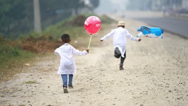 View of two boys running with balloons on a dirt road Bangladesh. View of two boys running with balloons on a dirt road Bangladesh.