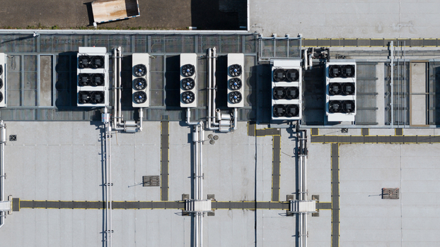 Aerial view of industrial HVAC cooling units and piping on a flat roof with yellow safety markings in Nieuwegein Utrecht Netherlands. Aerial view of industrial HVAC cooling units and piping on a flat roof with yellow safety markings in Nieuwegein Utrecht Netherlands.