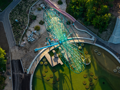 Aerial view of the iconic Ferris wheel at Spreepark in Berlin surrounded by lush green parkland pathways and shadows cast during the golden hour in Berlin Berlin Germany. Aerial view of the iconic Ferris wheel at Spreepark in Berlin surrounded by lush green parkland pathways and shadows cast during the golden hour in Berlin Berlin Germany.