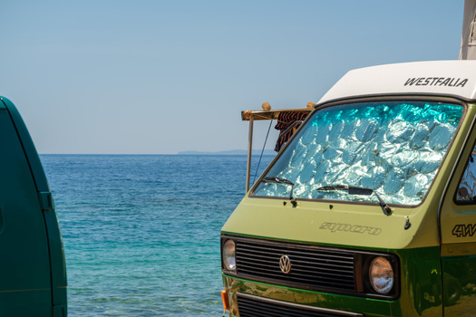 Jala Albania 12 June 2026 View of a vintage green Volkswagen Westfalia Syncro camper van parked by the turquoise waters of Aquarium Beach under a clear blue sky.
