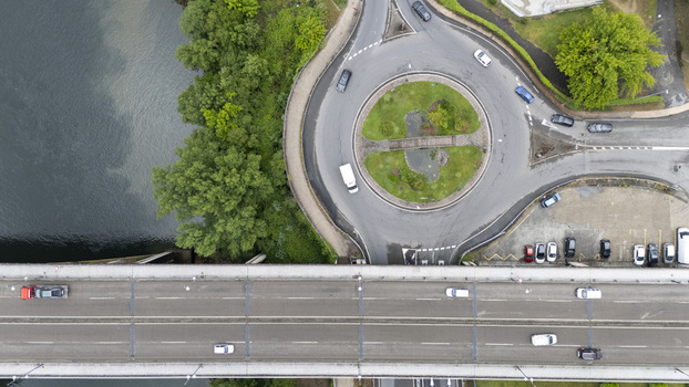 Aerial view of Ponte do Ribeirino bridge crossing the river next to a busy roundabout and lush green trees in Ourense Ourense Spain.