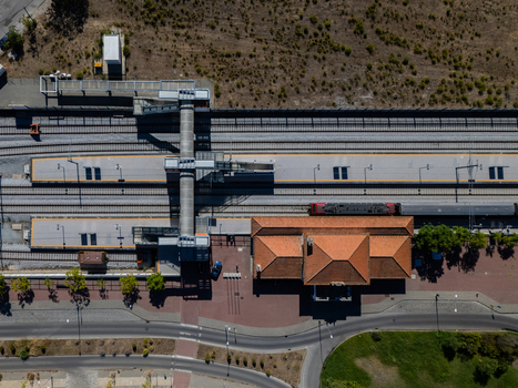 Aerial view of the train station with railway tracks platforms and a historic building with a tiled roof in Evora Evora District Portugal. Aerial view of the train station with railway tracks platforms and a historic building with a tiled roof in Evora Evora District Portugal.
