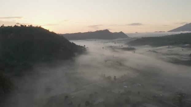 Aerial view of misty valley and rolling hills at sunrise Indonesia. Aerial view of misty valley and rolling hills at sunrise Indonesia.