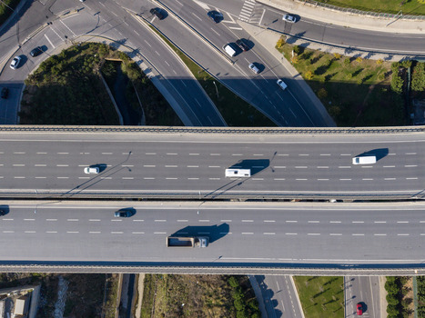 Aerial view of a multi lane highway bridge with cars and trucks driving on the asphalt surrounded by green roadside vegetation and connecting roads in Istanbul Istanbul Turkiye.