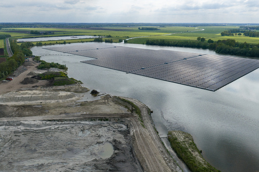 Aerial view of a large floating solar farm on a lake surrounded by green fields and a sand quarry in Beilen Drenthe Netherlands. Aerial view of a large floating solar farm on a lake surrounded by green fields and a sand quarry in Beilen Drenthe Netherlands.