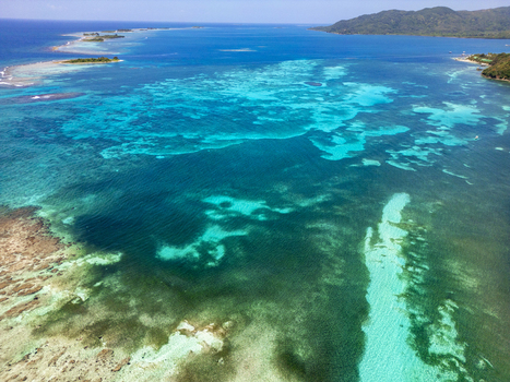 Aerial view of the turquoise coral reefs and crystal clear waters surrounding the island of Guanaja Bay Islands Department Honduras. Aerial view of the turquoise coral reefs and crystal clear waters surrounding the island of Guanaja Bay Islands Department Honduras.