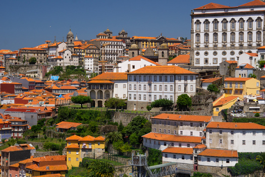 Aerial view of terracotta roofs cascade down the hillsides ancient buildings rise towards the clear sky in Porto Porto Porto District Portugal. Aerial view of terracotta roofs cascade down the hillsides ancient buildings rise towards the clear sky in Porto Porto Porto District Portugal.