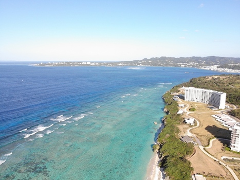 Aerial view of Sesoko Island with its turquoise coral reefs clear blue water and coastal resort hotels along the shoreline in Motobu Okinawa Japan. Aerial view of Sesoko Island with its turquoise coral reefs clear blue water and coastal resort hotels along the shoreline in Motobu Okinawa Japan.