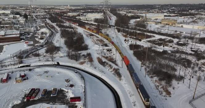 Aerial view of a freight train moving through a snowy landscape United States. Aerial view of a freight train moving through a snowy landscape United States.