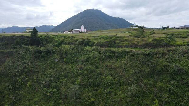 Aerial view of Tara Bunga in the highlands with lush green vegetation rolling hills and a cloudy sky in Tampahan North Sumatra Indonesia. Aerial view of Tara Bunga in the highlands with lush green vegetation rolling hills and a cloudy sky in Tampahan North Sumatra Indonesia.