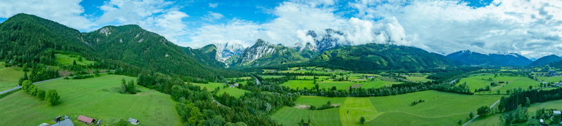 Aerial view of Nationalpark Gesause with winding rivers green valleys scattered houses and dramatic mountain peaks such as Admonter Reichenstein and Hochtor in Admont Steiermark Austria.