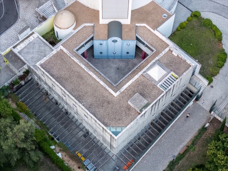 Alges Portugal 25 July 2026 Aerial view of Santissima Trindade Church showing its unique geometric architecture flat gravel rooftops and surrounding paved walkways.
