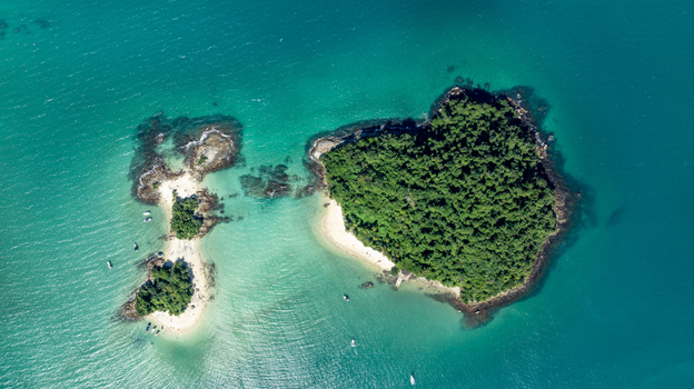 Aerial view of Ilha de Cataguas featuring lush green vegetation white sandy beaches and turquoise waters in the Atlantic Ocean Angra dos Reis Rio de Janeiro Brazil.