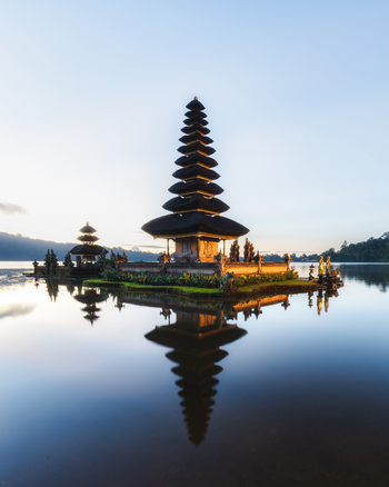 View of the serene temple standing majestically on the water its tiered structure mirrored in the tranquil lake under a soft sky Bali Bali Indonesia.