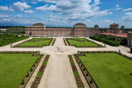 Aerial view of La Venaria Reale palace and its symmetrical formal gardens under a blue sky with white clouds in Venaria Reale Piemonte Italy. Aerial view of La Venaria Reale palace and its symmetrical formal gardens under a blue sky with white clouds in Venaria Reale Piemonte Italy.
