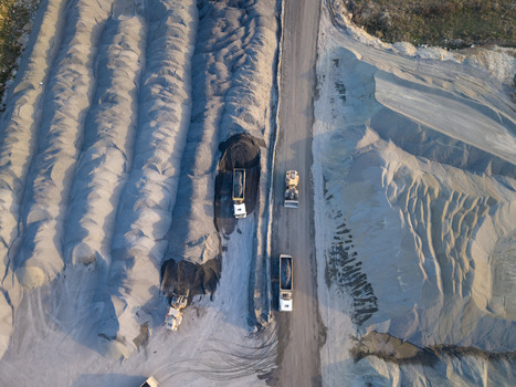 Aerial view of a quarry with piles of gravel and sand heavy machinery and trucks driving on a dirt road in Istanbul Istanbul Turkiye.