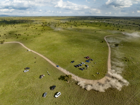 Aerial view of Swara Plains Conservancy with people standing near off road vehicles on dirt tracks across the green savanna in Nairobi Machakos County Kenya. Aerial view of Swara Plains Conservancy with people standing near off road vehicles on dirt tracks across the green savanna in Nairobi Machakos County Kenya.
