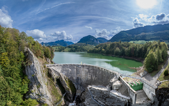 Aerial view of Barrage de Montsalvens dam with its curved concrete wall surrounded by forests rocky cliffs and the turquoise reservoir in Chatel sur Montsalvens Fribourg Switzerland. Aerial view of Barrage de Montsalvens dam with its curved concrete wall surrounded by forests rocky cliffs and the turquoise reservoir in Chatel sur Montsalvens Fribourg Switzerland.