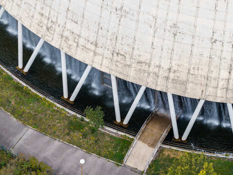 Aerial view of the cooling tower at Heizkraftwerk Reuter West with water cascading down the concrete structure supported by white pillars in Berlin Berlin Germany.