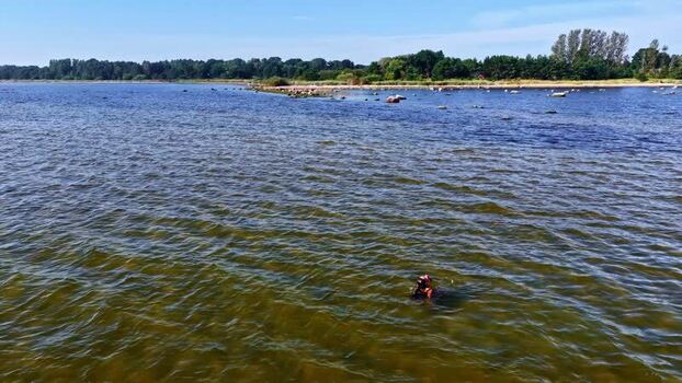 Aerial view of a person swimming in the sea in Latvia. Aerial view of a person swimming in the sea in Latvia.