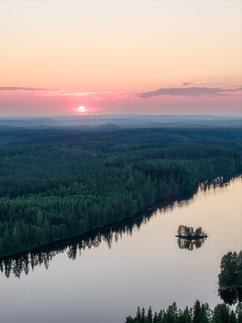 Aerial view of Laaminki lake at sunset with dense pine forests and calm reflective water in Kangasniemi Etela Savo Finland. Aerial view of Laaminki lake at sunset with dense pine forests and calm reflective water in Kangasniemi Etela Savo Finland.