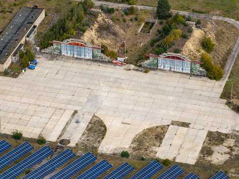 Aerial view of the solar field at the former military airfield in Preschen featuring historic hangars and concrete taxiways near rows of solar panels in Neisse Malxetal Brandenburg Germany. Aerial view of the solar field at the former military airfield in Preschen featuring historic hangars and concrete taxiways near rows of solar panels in Neisse Malxetal Brandenburg Germany.