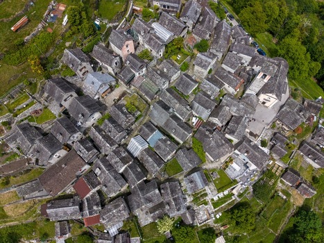 Aerial view of the dense cluster of traditional stone houses and slate roofs in Corippo Albergo Diffuso within the Verzasca Valley Corippo Ticino Switzerland. Aerial view of the dense cluster of traditional stone houses and slate roofs in Corippo Albergo Diffuso within the Verzasca Valley Corippo Ticino Switzerland.