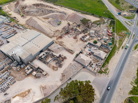 Aerial view of the Philippi sand quarry featuring industrial buildings piles of sand and heavy machinery in Cape Town Western Cape South Africa.