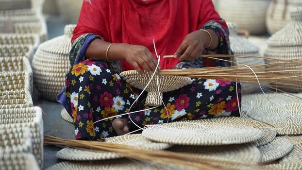 View of a woman weaving traditional baskets Bangladesh. View of a woman weaving traditional baskets Bangladesh.