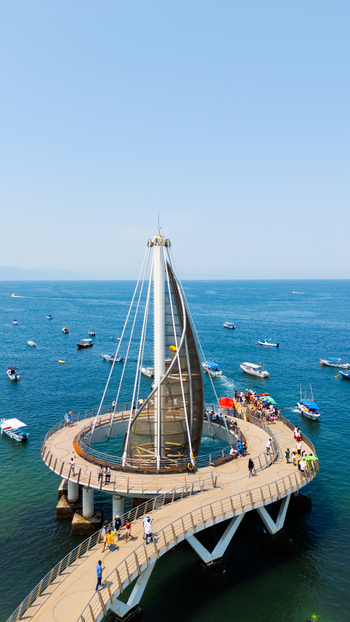 Aerial view of Los Muertos Pier stretching into the shimmering bay a modern marvel against the azure sea Puerto Vallarta Jalisco Mexico.
