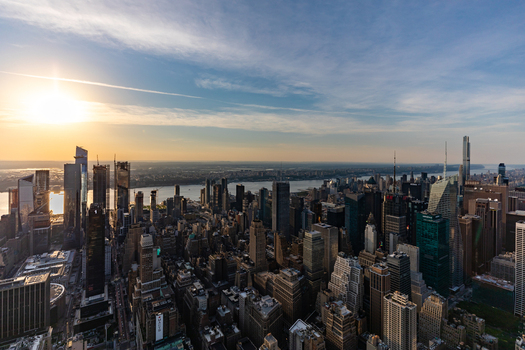 New York New York United States 09 August 2021 Aerial view of the Manhattan skyline at sunset with skyscrapers the Hudson River and golden light reflecting on the buildings.