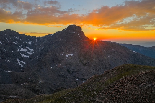 Aerial view of Mount of the Holy Cross at sunrise with golden light illuminating the rugged peaks and snow patches in the Sawatch Range Vail Colorado United States. Aerial view of Mount of the Holy Cross at sunrise with golden light illuminating the rugged peaks and snow patches in the Sawatch Range Vail Colorado United States.