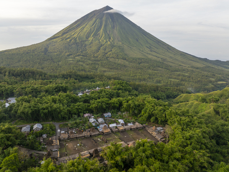 Aerial view of Bena Traditional Village at the foot of Mount Inerie featuring traditional houses and lush volcanic slopes in Bajawa Nusa Tenggara Timur Indonesia.