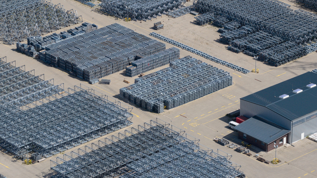Aerial view of the Amprion Gmbh industrial facility featuring organized stacks of metal power grid components and a warehouse in Herten Nordrhein Westfalen Germany.