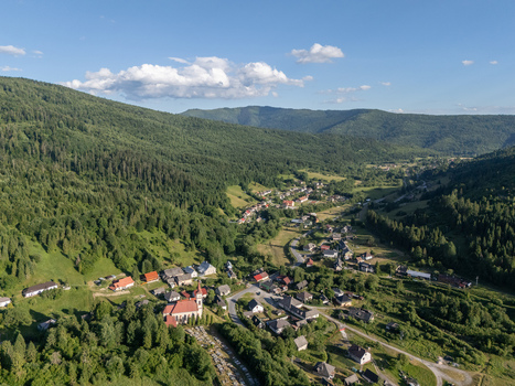 Aerial view of a quaint village nestled in a valley surrounded by lush green forests under a bright sky Hnilec Kosice Region Slovakia. Aerial view of a quaint village nestled in a valley surrounded by lush green forests under a bright sky Hnilec Kosice Region Slovakia.