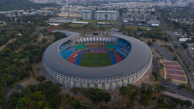 Aerial view of Kaohsiung National Stadium featuring its unique spiral solar panel roof and athletic track surrounded by lush greenery Juguang Village Kaohsiung City Taiwan.