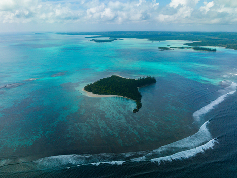 Aerial view of an island surrounded by vibrant turquoise waters where the ocean s depths transition from light to dark Noumea New Caledonia. Aerial view of an island surrounded by vibrant turquoise waters where the ocean s depths transition from light to dark Noumea New Caledonia.
