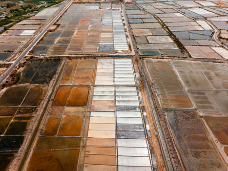 Aerial view of salt pans with geometric patterns and varying water colors in Vietnam. Aerial view of salt pans with geometric patterns and varying water colors in Vietnam.