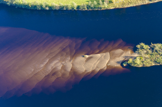 Aerial view of Klaralven river showing intricate sandbars and sediment patterns along the water in Varmlands lan Sweden. Aerial view of Klaralven river showing intricate sandbars and sediment patterns along the water in Varmlands lan Sweden.