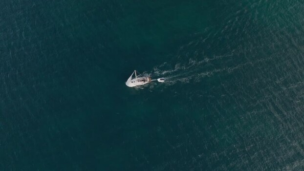 Aerial view of a sailboat cruising on the blue sea Italy. Aerial view of a sailboat cruising on the blue sea Italy.