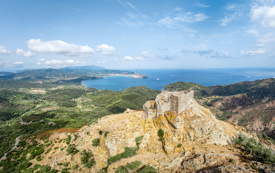 Aerial view of the historic Castello del Volterraio perched on a rocky hill overlooking the Mediterranean sea and the bay of Portoferraio Toscana Italy.