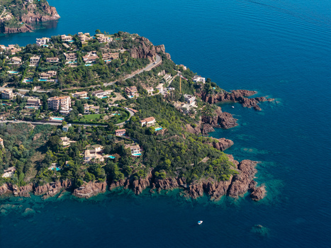 Aerial view of Le Trayas coastline featuring rocky red cliffs Mediterranean Sea lush vegetation and coastal villas in Saint Raphael Provence Alpes Cote d Azur France. Aerial view of Le Trayas coastline featuring rocky red cliffs Mediterranean Sea lush vegetation and coastal villas in Saint Raphael Provence Alpes Cote d Azur France.
