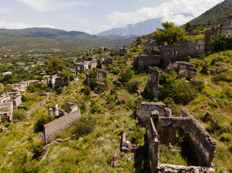 Aerial view of the historic stone ruins of Kayakoy ghost village surrounded by lush greenery and mountains in Fethiye Mugla Turkiye. Aerial view of the historic stone ruins of Kayakoy ghost village surrounded by lush greenery and mountains in Fethiye Mugla Turkiye.