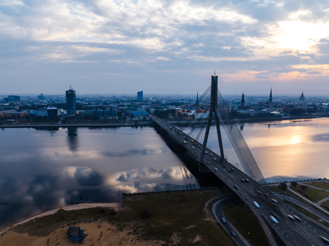 Aerial view of the cable stayed Vansu Bridge spanning the Daugava River at sunset with the city skyline of Riga in the background Riga Latvia. Aerial view of the cable stayed Vansu Bridge spanning the Daugava River at sunset with the city skyline of Riga in the background Riga Latvia.