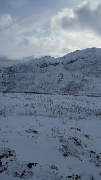 Aerial view of snowy mountains on Kvaloya island Norway.