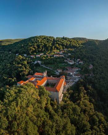 Aerial view of the Monastery of Santo Estevo de Ribas de Sil nestled in the lush forests of Ribeira Sacra with stone architecture and terracotta rooftops in O Covelo Ourense Spain.